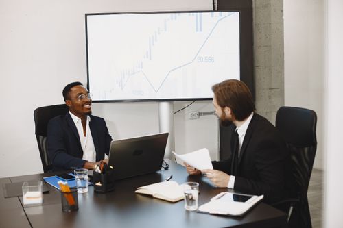 Foto van een zakelijk overleg tussen twee bestuurders over de groei van hun bedrijf